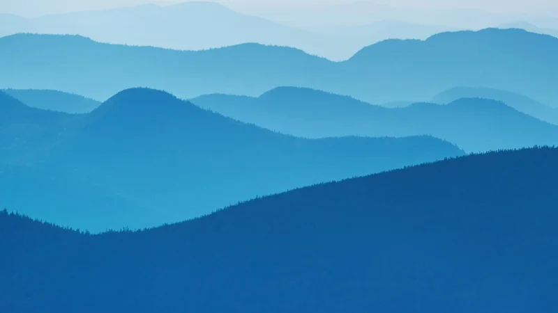 Blue mountain ridges fading into the haze.