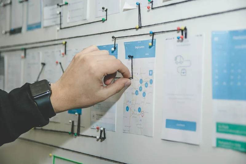 Hand placing a pin on a project
