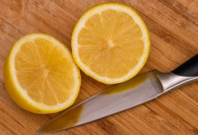 A sliced lemon next to a knife